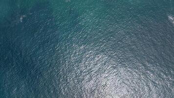 View of the ocean water surface showing sparkling teal waves and sunlight reflections video