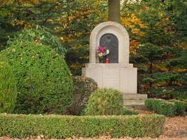 A statue of a man in a park surrounded by trees photo