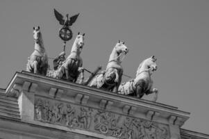 A black and white photo of statues on top of a building
