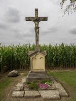 A cross is in front of a corn field photo