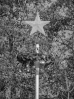 A black and white photo of a star on top of a pole