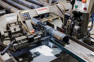 Precision in Motion A Gleaming Metalworking Machine Skillfully Carves Through a Sturdy Pipe, Emitting Sparks of Innovation. photo