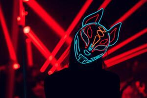 Illuminated Mystery A vibrant figure shrouded in a glowing mask stands against a backdrop of pulsating red light beams, merging intrigue with electrifying energy. photo