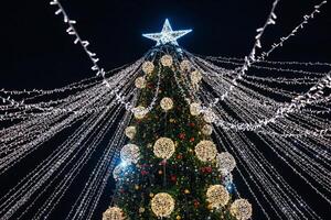 Radiant Holiday Cheer A Glimmering Christmas Tree Adorned with Twinkling Lights and a Shining Star, Capturing the Essence of Festive Joy. photo