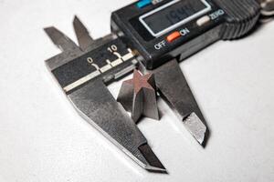 Precision in Form A Caliper Captures the Intricacies of a Star-Shaped Metal Design photo