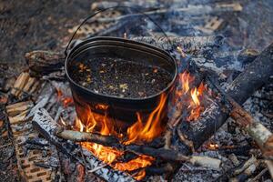 Natures Boil A bubbling pot dances over a crackling campfire, steam rising in the twilight, as the warmth of outdoor cooking embraces the wilderness. photo