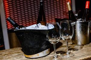 Chilling Elegance A Still Life of Wine Bottles Nestled in Ice Buckets, Surrounded by Sparkling Glasses Awaiting the Perfect Toast. photo