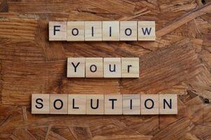follow your solution text on wooden square photo