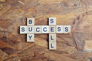 Buy sell success text on wooden square photo