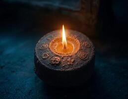 a candle is lighten up on a dark background surrounded by various religious symbols on it photo
