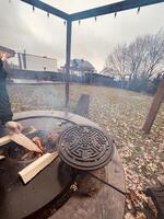 Outdoor fire pit with wooden logs in a cozy backyard setting photo