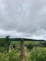 Scenic rural landscape with historical stone monument and cloudy sky photo