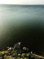 Tranquil lakeside view with rocky shoreline and expansive water photo