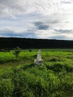 Ancient stone monument in tranquil rural field landscape photo
