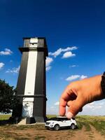 Creative optical illusion with hand pinching a tall tower photo
