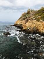 Scenic rocky coastline with waves crashing against the shore. Bodrum, Turkey. photo