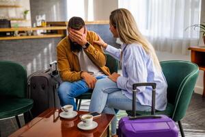 Young couple is going on vacation. Tourists sitting at airport cafe because of delayed flight. photo