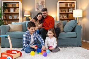 A family playing with toys on a white rug photo