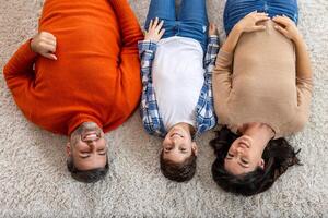 A family laying on the floor with their arms up photo