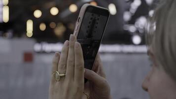 A person is capturing a special moment using their smartphone at a lively public event. Clip photo
