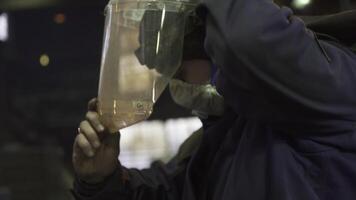 A skilled worker carefully analyzing materials under challenging low light conditions in a factory. Stock Clip photo