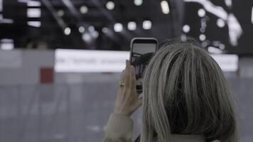 A woman deeply engaged in photographing a lively event. Clip. Capturing the Essence of the Moment at a Live Event for Everyone to Experience and Enjoy photo