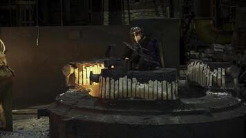 Workers in a foundry are engaged in the skillful casting of metal materials and components. Stock Clip photo