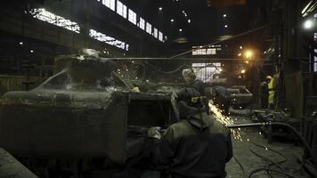 An Industrial Workshop featuring Workers engaged in various tasks within a Foundry setting. Stock Clip photo