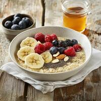 Oatmeal with banana, blueberries, raspberries and chia seeds on a wooden background photo