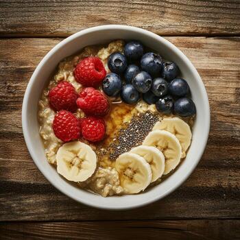 Oatmeal with banana, blueberries, raspberries and chia seeds on a wooden background photo