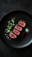 Grilled wagyu beef steak with arugula on black plate photo
