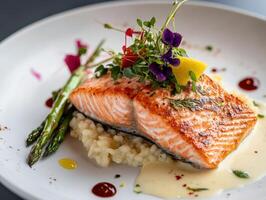 Grilled salmon with risotto and asparagus on a white plate photo
