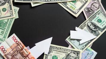 Business and finance concept. Paper arrows and money on black background. photo