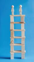 Businessman standing on ladder on blue background. Concept of career growth photo