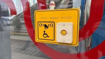 Sign for disabled person with braille text and help button to call assistant for people with disabilities in front of metro entrance. Public amenities in modern city for people with disabilities photo