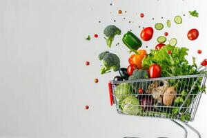 A long format copy space image featuring fresh vegetables falling into a shopping basket on a white background photo