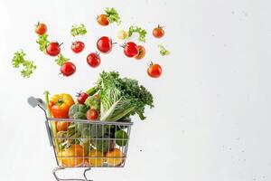 A long format copy space image featuring fresh vegetables falling into a shopping basket on a white background photo