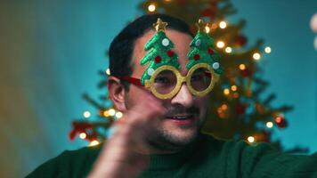 Man Makes Call With Phone Against Christmas Tree Background In Home video