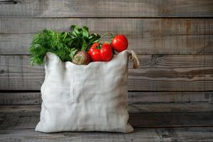 White linen bag with vegetables is placed on a rustic wooden background photo