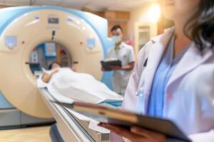 A doctor with a clipboard and a patient in a CT scanner, showcasing modern healthcare diagnostics. Selective focus photo