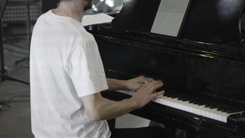 A talented musician is skillfully playing the beautiful piano in a professional studio setting. Clip photo