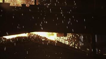In an industrial setting, hot metal is poured with dazzling sparks, showing expertise and skill. Stock Clip photo
