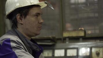 A highly focused technician diligently working within an industrial factory setting. Stock Clip photo