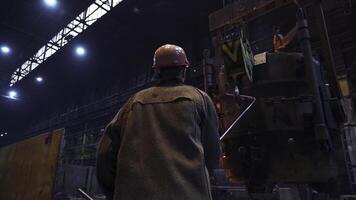 An Industrial Worker Concentrating on Operating Heavy Machinery Within a Factory Setting. Stock Clip photo