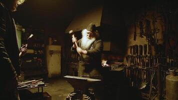 Skilled Master Blacksmith Busy at Work in a Traditional and Authentic Forge Environment. Stock Clip photo