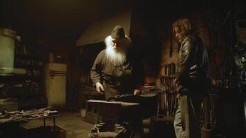 Skilled craftsmen in the workshop, featuring a blacksmith and their dedicated apprentice. Stock Clip photo