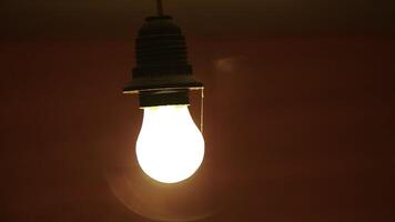 A Glowing Red Light Bulb Brightly Illuminating a Dark Setting for an Intimate Atmosphere. Stock Clip photo