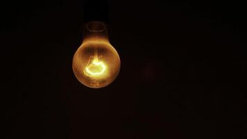 An Illuminated Light Bulb Set Against a Dark Background Creating a Striking Visual Contrast. Stock Clip photo