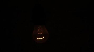 A Glowing Red Light Bulb Brightly Illuminating a Dark Setting for an Intimate Atmosphere. Stock Clip photo