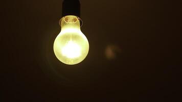 An Illuminated Light Bulb Set Against a Dark Background Creating a Striking Visual Contrast. Stock Clip photo